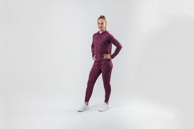 The REP Fitness Women's Vellus Hoodie in Heather Wine side, hand on hip