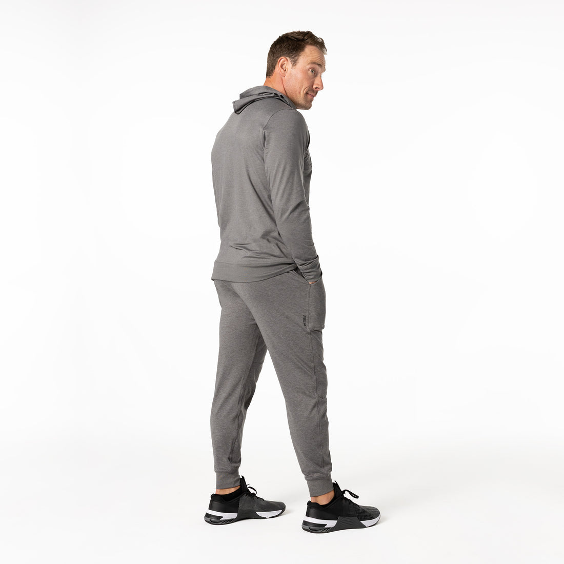 The REP Fitness Men's Apollo Hoodie in Heather Cool Gray back, looking over shoulder
