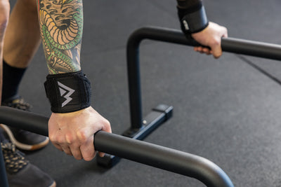 Athlete using wrist wraps with the REP Fitness Parallette Bars