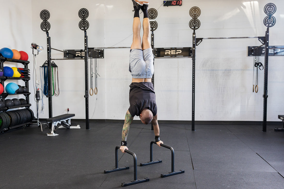 Athlete performing a handstand on the REP Fitness Parallette Bars