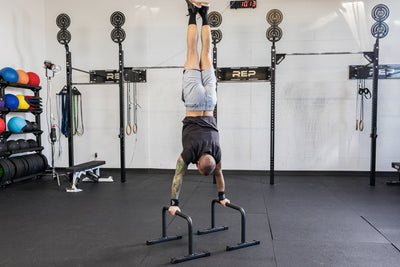 Athlete performing a handstand on the REP Fitness Parallette Bars