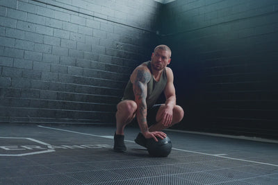 AAthlete wearing the REP Fitness Men's Motus Shorts in Silver, Black, Slate during Slam Ball training
