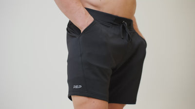 Athlete wearing the REP Fitness Men's Attis Shorts in Heather Olive, Heather Black, Heather Cool Gray close-up