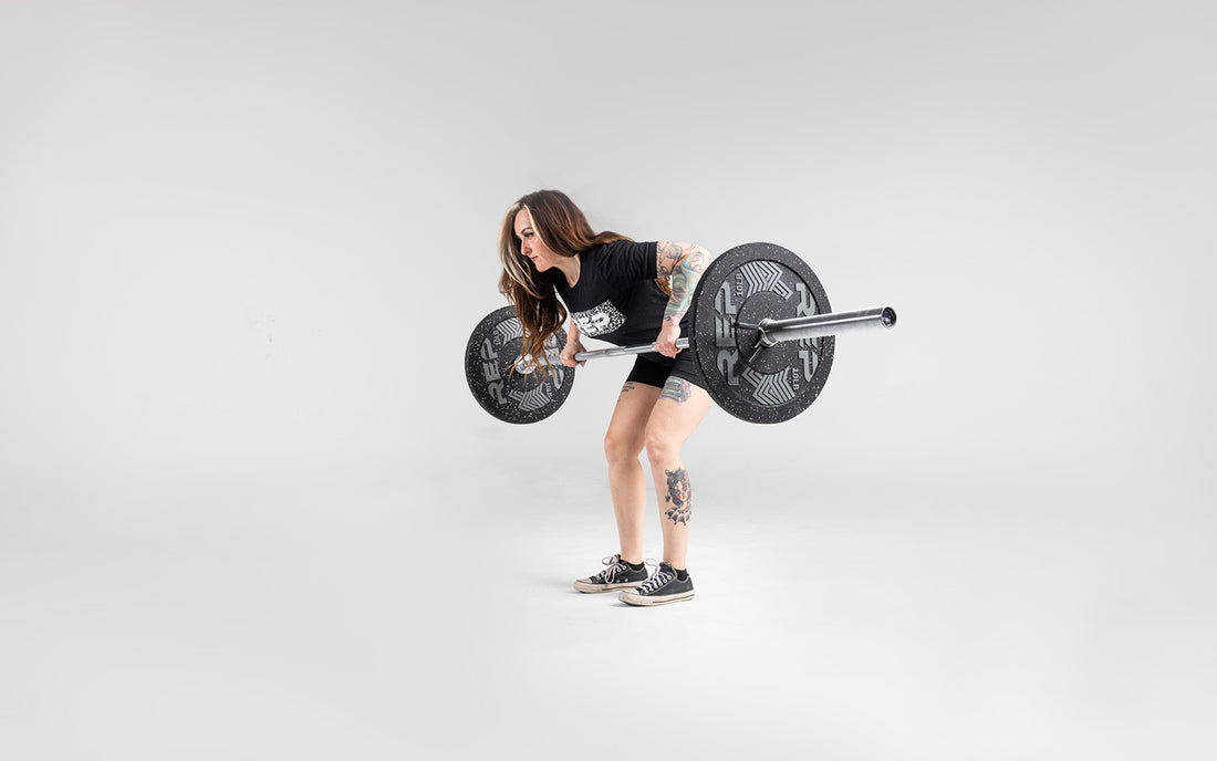 Lifter performing a bent over row with a barbell loaded with a pair of 10lb pinnacle bumper plates.