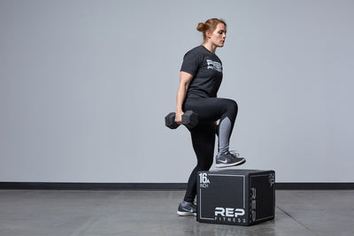 Individual performing weighted box step-ups on the Small REP 3-in-1 Soft Plyo Box.