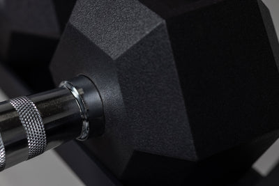 Close-up view of the chrome ergonomic handle meeting the rubber-coated hexagon head of a REP Ergo Hex Dumbbell.